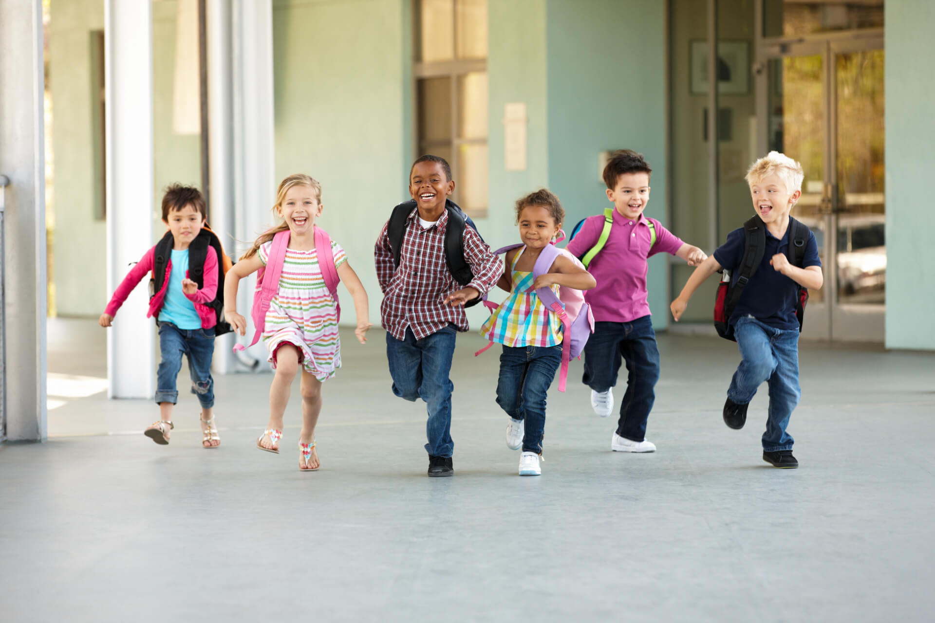 Group of elementary age schoolchildren running outside